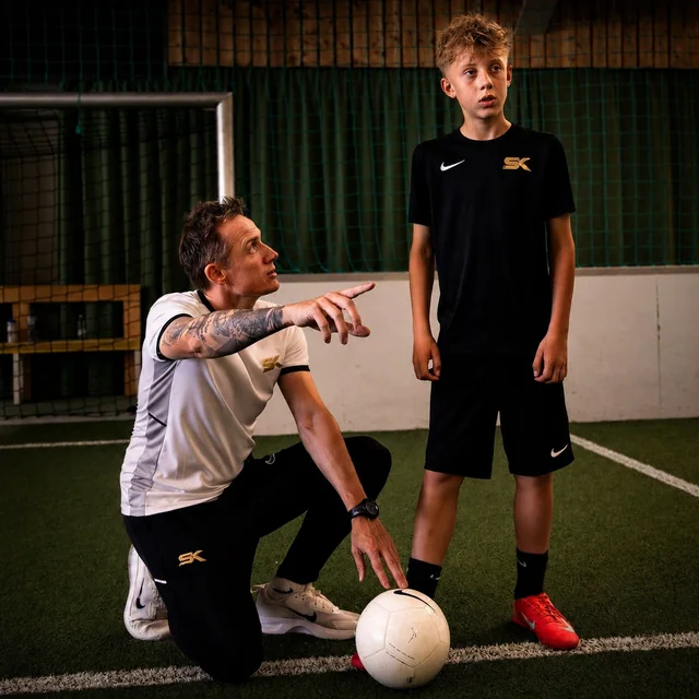 Stefan Kehrer erklärt einem jungen Fußballer eine Spielsituation in der Soccerhalle